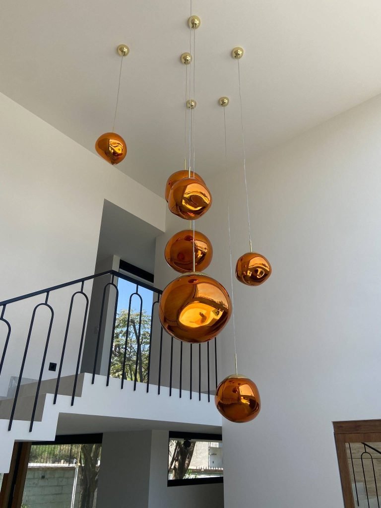 Diseño interior elegante con escaleras y luminarias que aportan estilo y calidez al vestíbulo.